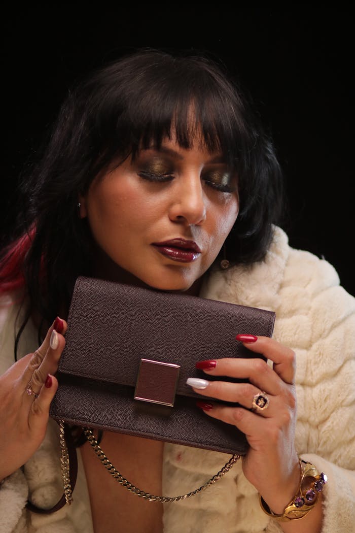 Sophisticated woman in fur coat embracing a luxury clutch bag.