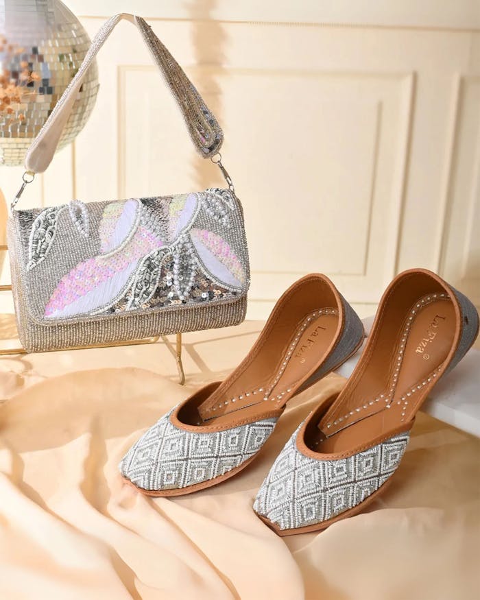Chic traditional footwear paired with a beaded purse on display, showcasing Indian craftsmanship.